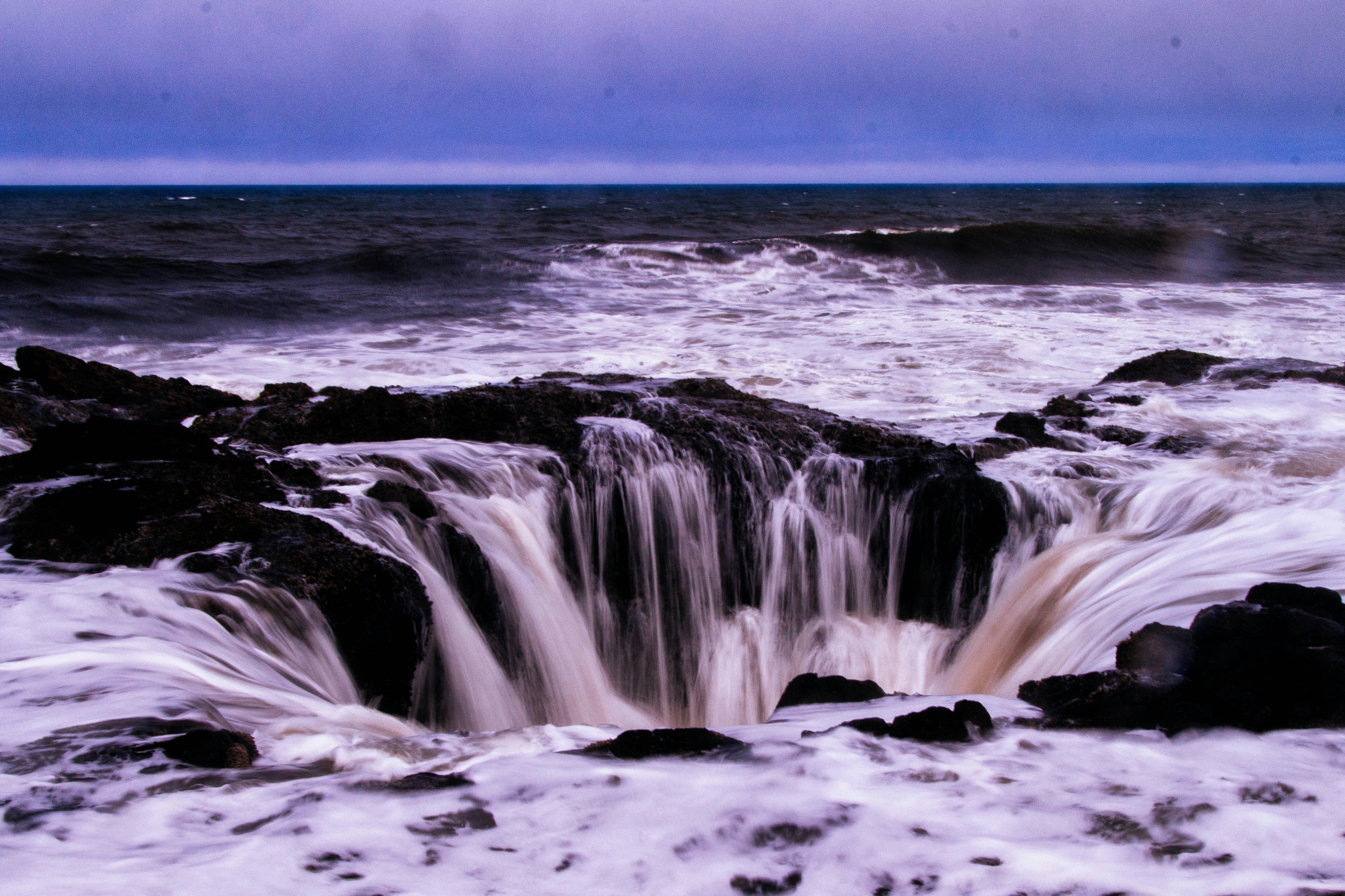 sea water falling into rocky hole at the beach
